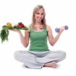 woman with food and barbell to demonstrate fitness and diet