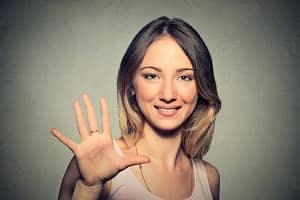 woman holding her hand up to show all of her fingers
