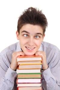 Image of a cross-eyed boy with books to express overwhelm with a language learning project