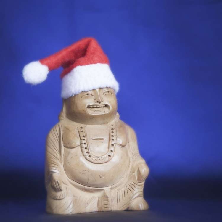 Image of a wooden Buddha with Santa Claus hat