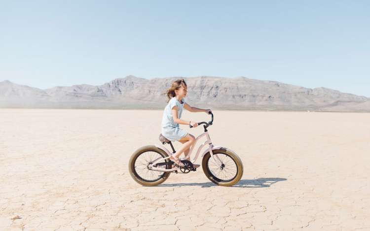 A girl riding her bike in the desert; an example of procedural memory.