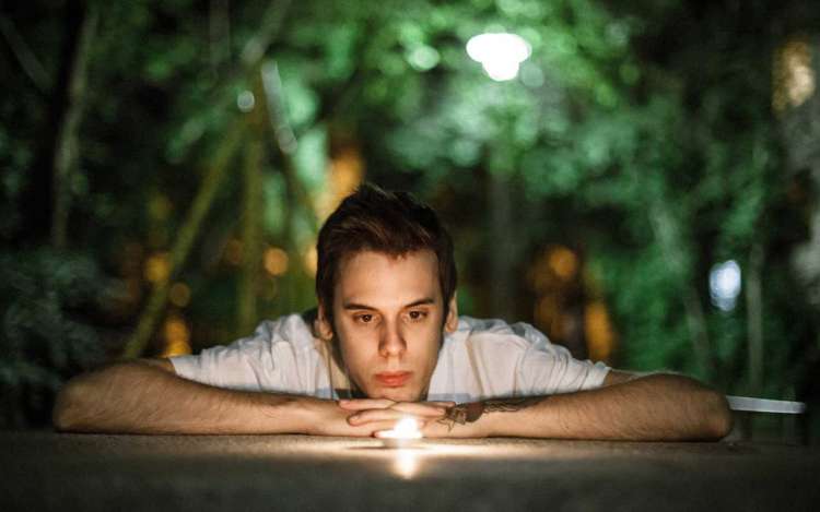 A man stares into a candle, a type of concentration meditation with an object focus.