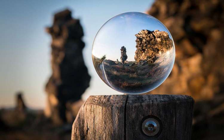 Memorizing a song creates focus and concentration. Picture of a clear globe on a post, looking out at a rock formation.