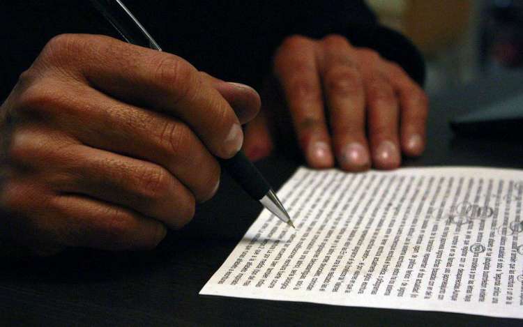 A person doing lyric analysis on paper, part of how to memorize a song.