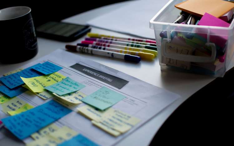 What is mind mapping? It can be used when you need to understand a project better. This image shows a desk with sticky notes, markers, and other office supplies.