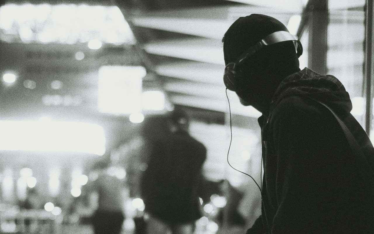 A person wearing headphones, looking over their shoulder and staying focused at work.