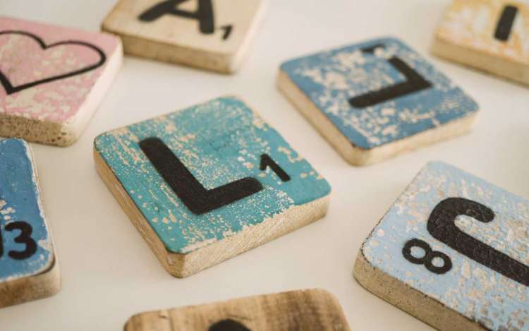 Hand painted Scrabble letters. Word games like Scrabble can help improve comprehension.