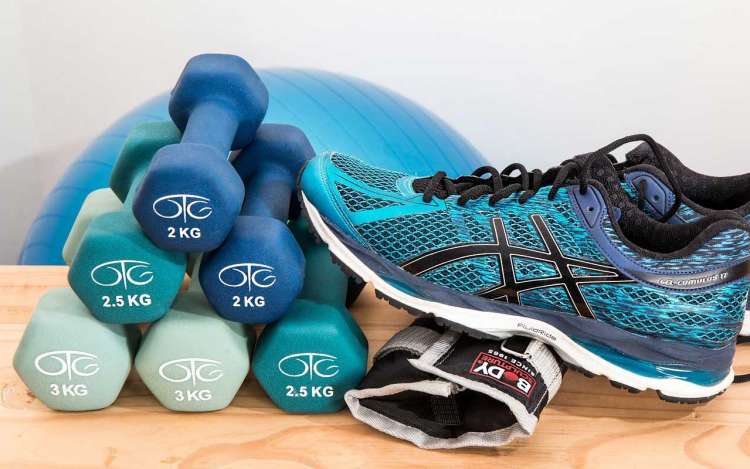 Exercise equipment, including a balance ball, dumbbells, and tennis shoes. Regular exercise is a great way to avoid long-term memory loss.