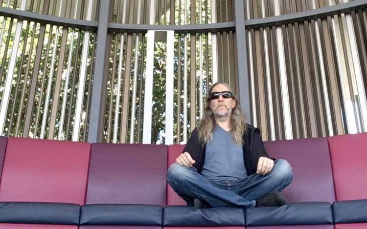 Anthony sits in meditation at his local university campus, practicing visualization meditation.