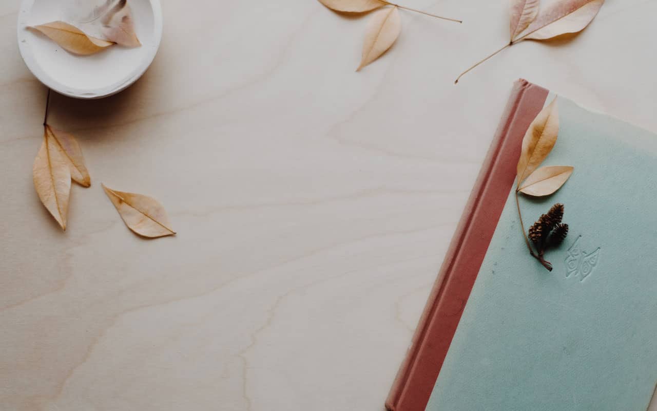 A journal on a wooden table. Journaling is a key component of successful guided visualization meditation.