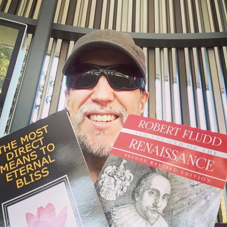 Anthony holds up two books, The Most Direct Means to Eternal Bliss and Robert Fludd and the End of the Renaissance.