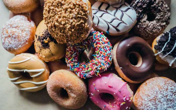 A pile of sugary donuts with various toppings. Foods made with refined sugar and flour are not natural memory enchancers.