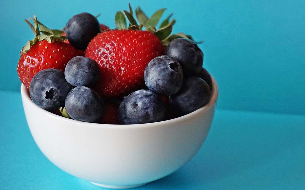 A bowl of blueberries and strawberries. Fruits like these have healthy levels of flavonoids.
