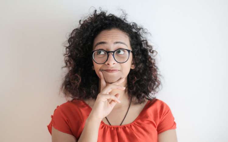 A woman wearing glasses looks skeptical that you can improve memory and recall.