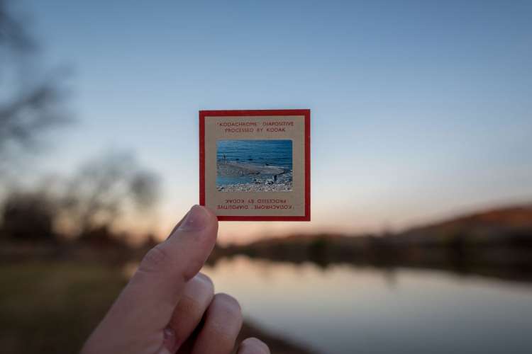 A person holds up a square Kodachrome negative. The square represents the even count of inhale, exhale, and breath retention in sama vritti pranayama (box breathing).