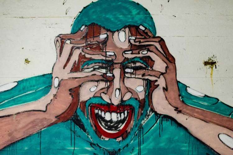 A painted mural of a stressed person holding their hands up to their head and screaming.