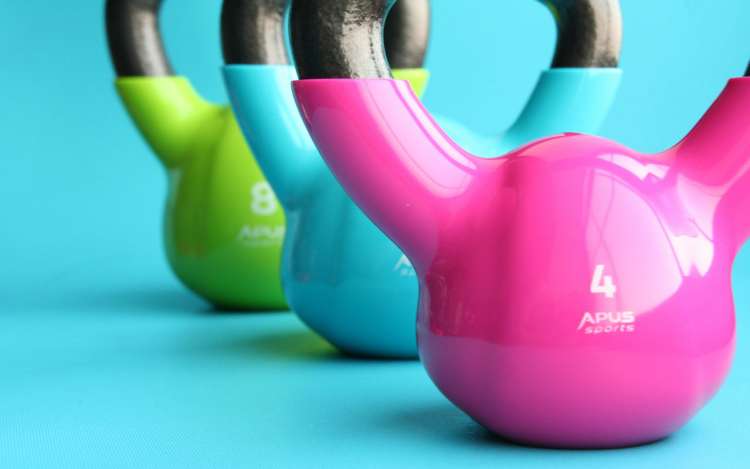 A set of blue, green, and pink kettlebells. Exercise helps you remember more.