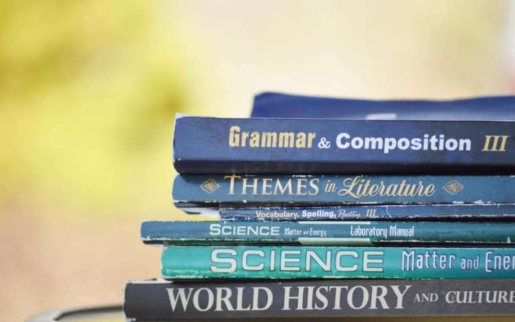 A stack of textbooks, including a Grammar & Composition book.