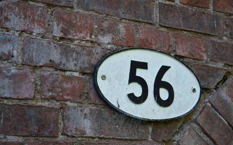 A house number "56" in white with black numbers against a brick wall. 56 was the second number in this example of an N-back Test.