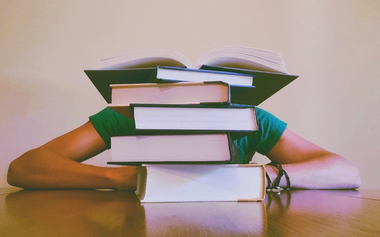 a man reading behind books