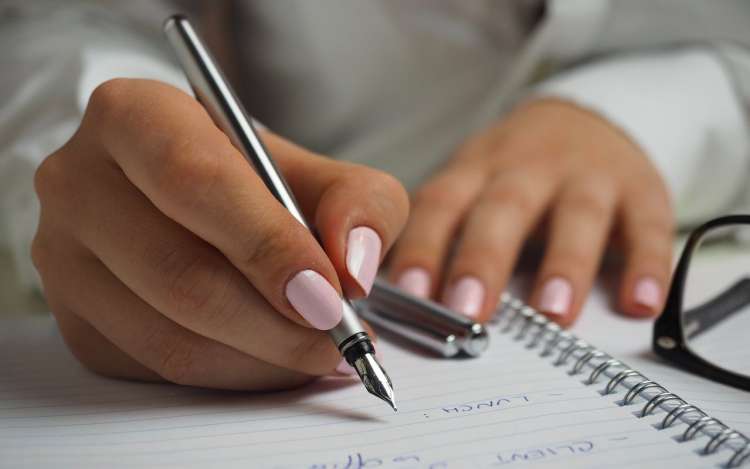 Woman writing in a journal.