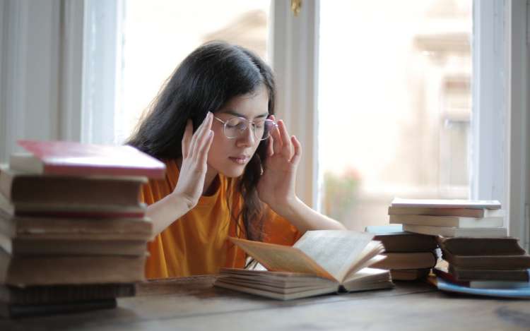 Young woman trying to mind read a book instead of using memory retention strategies