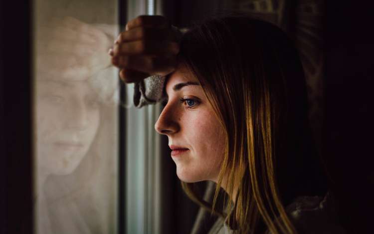 a woman is thinking with her arm on the window