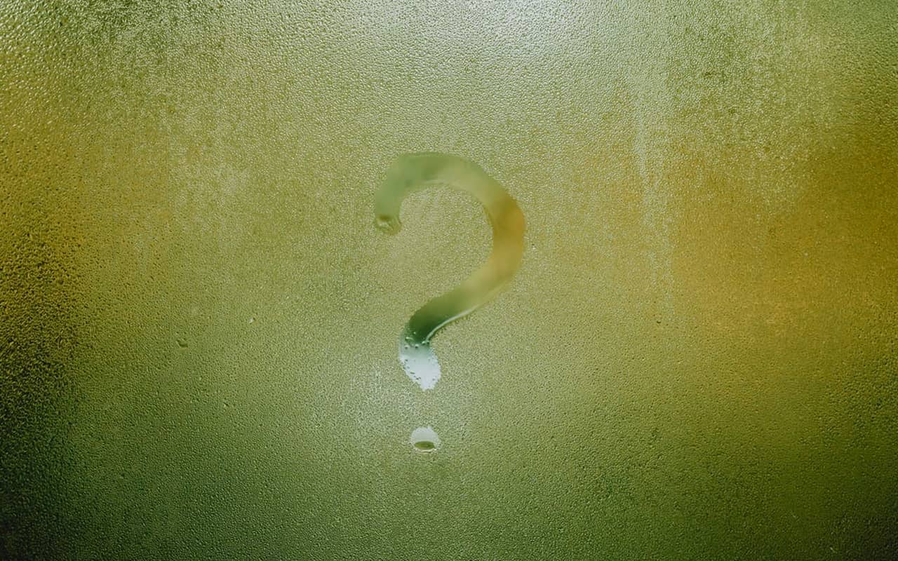 a frosted window with a question mark streaked on it