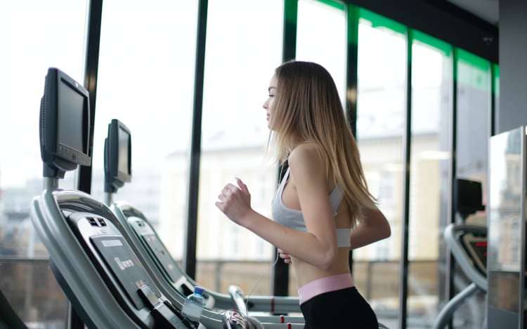 a woman is doing cardio exercise in a gym