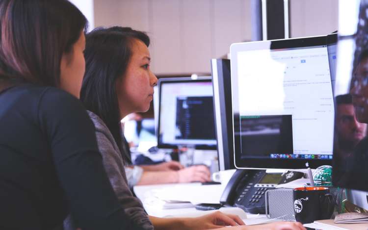 two women are working with a computer