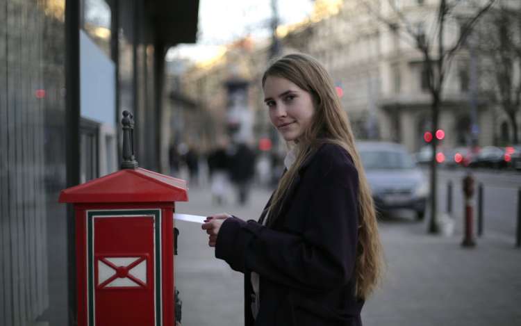 a woman is sending a postcard