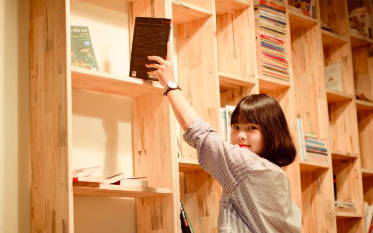 a woman getting a book from a shelf