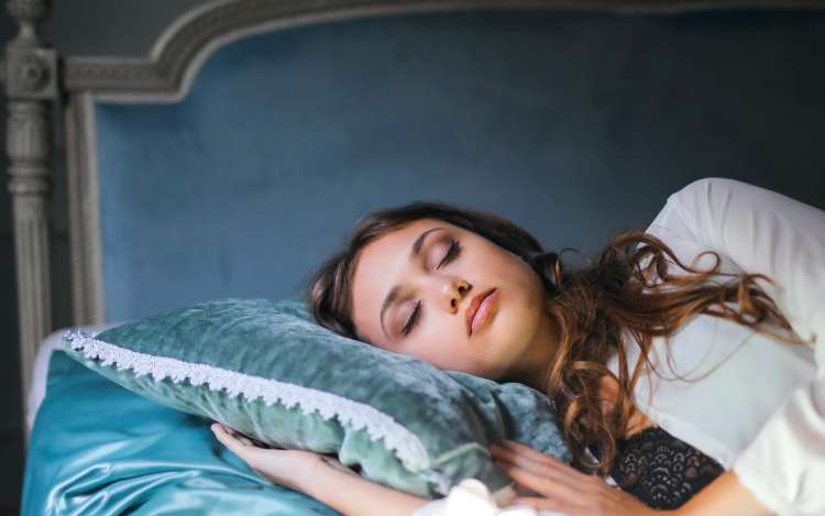 a women is sleeping on a blue pillow