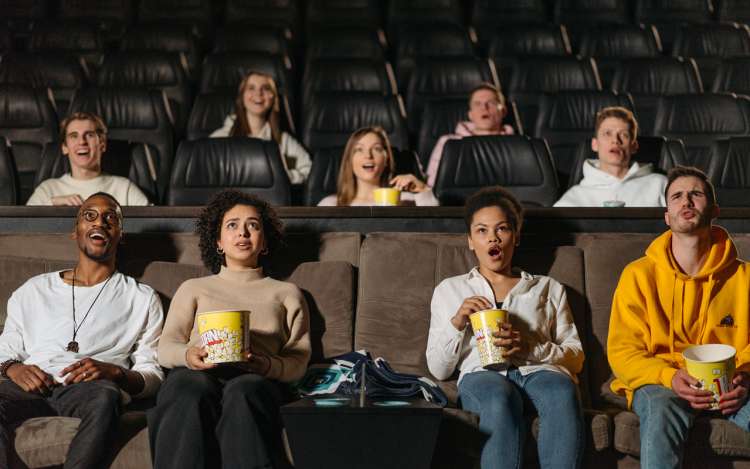 people watching a movie and eating popcorns