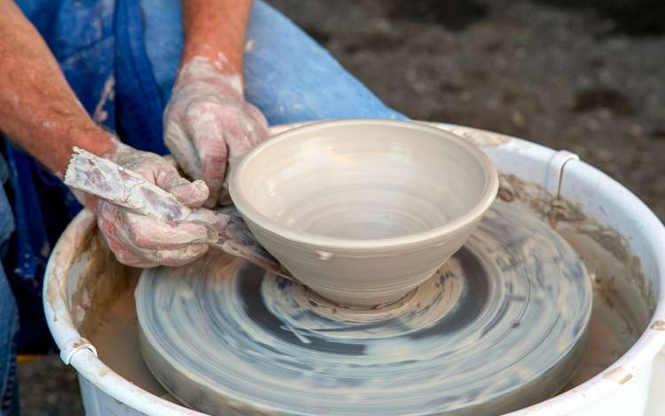 a man is making a clay pot