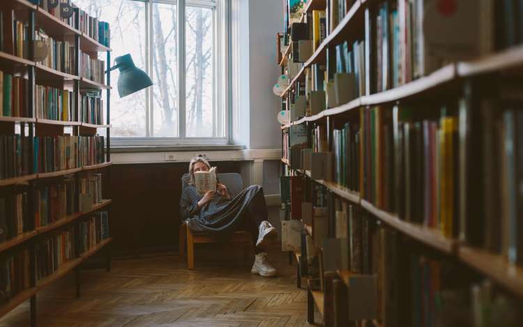 a woman laying on a sofa and enjoying reading