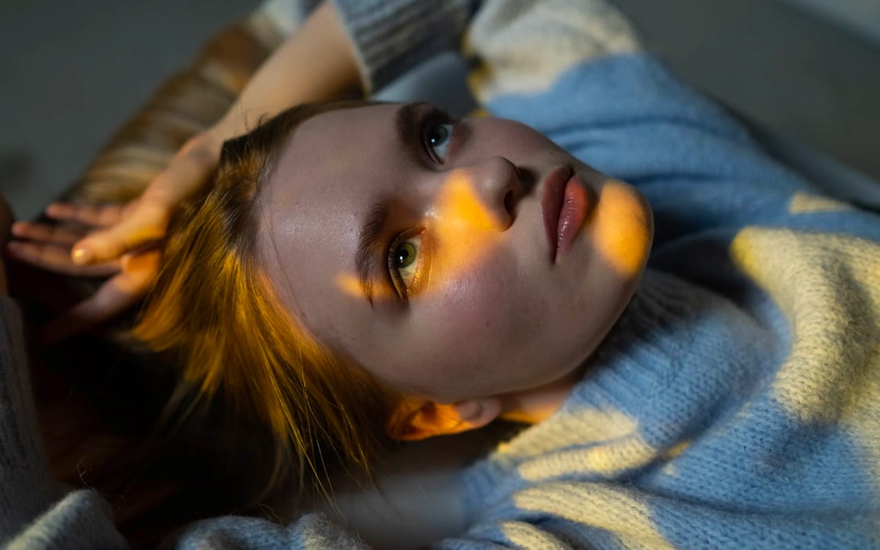 a woman laying on the floor and thinking