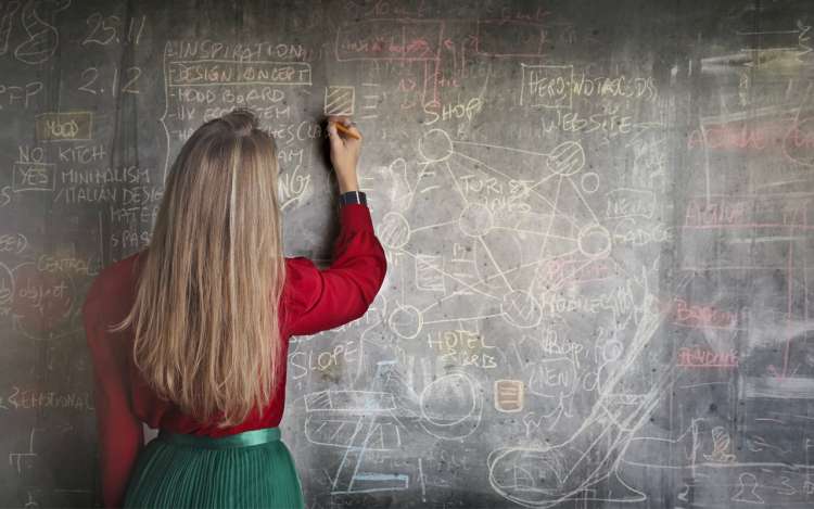 long hair woman drawing on a chalkboard