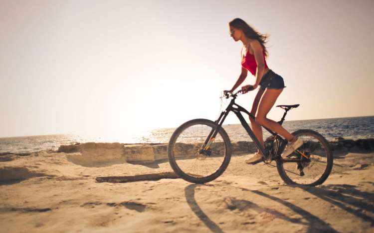 一个女人正沿着大海骑着自行车