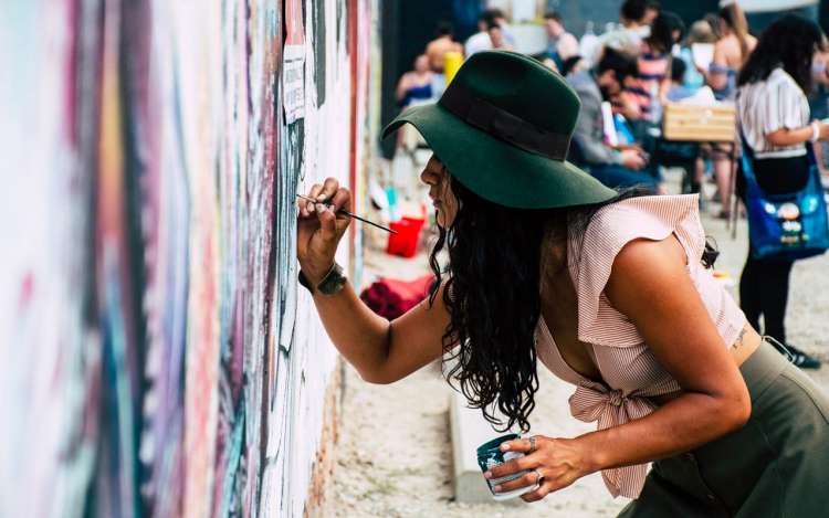 green hat artist drawing on a wall