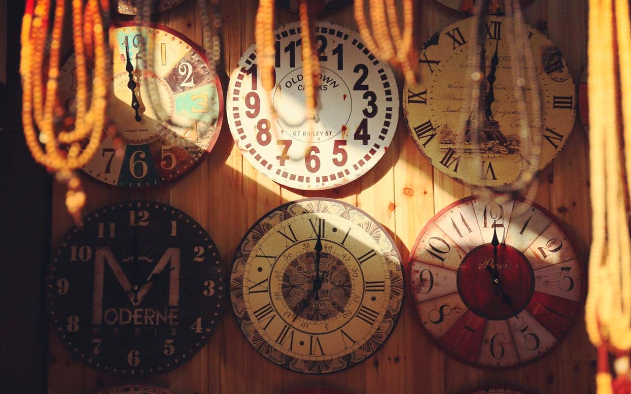 six clocks on a wooden wall