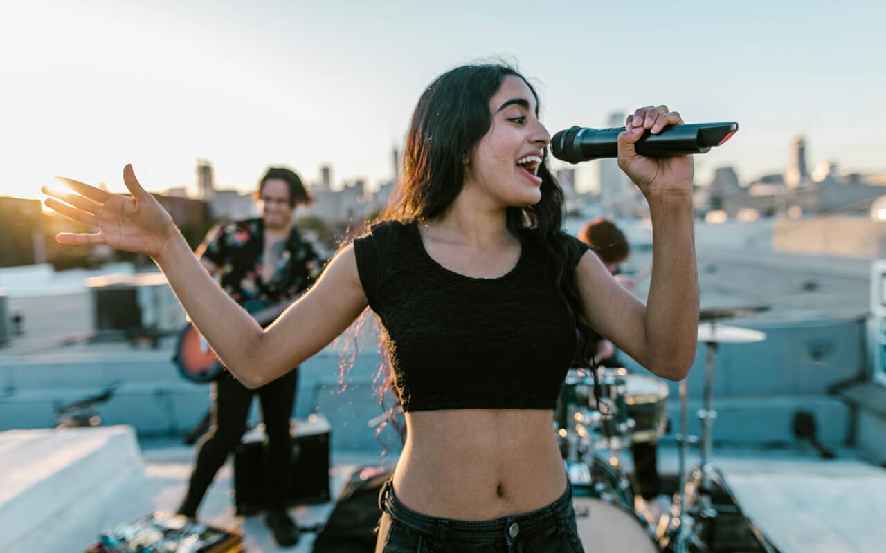 a girl is singing on a roof