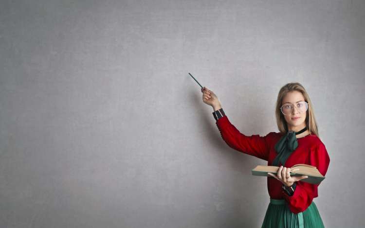 a woman is teaching in front of a blackboard