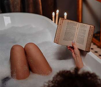 benefits of reading woman relaxed with book in a hot tub