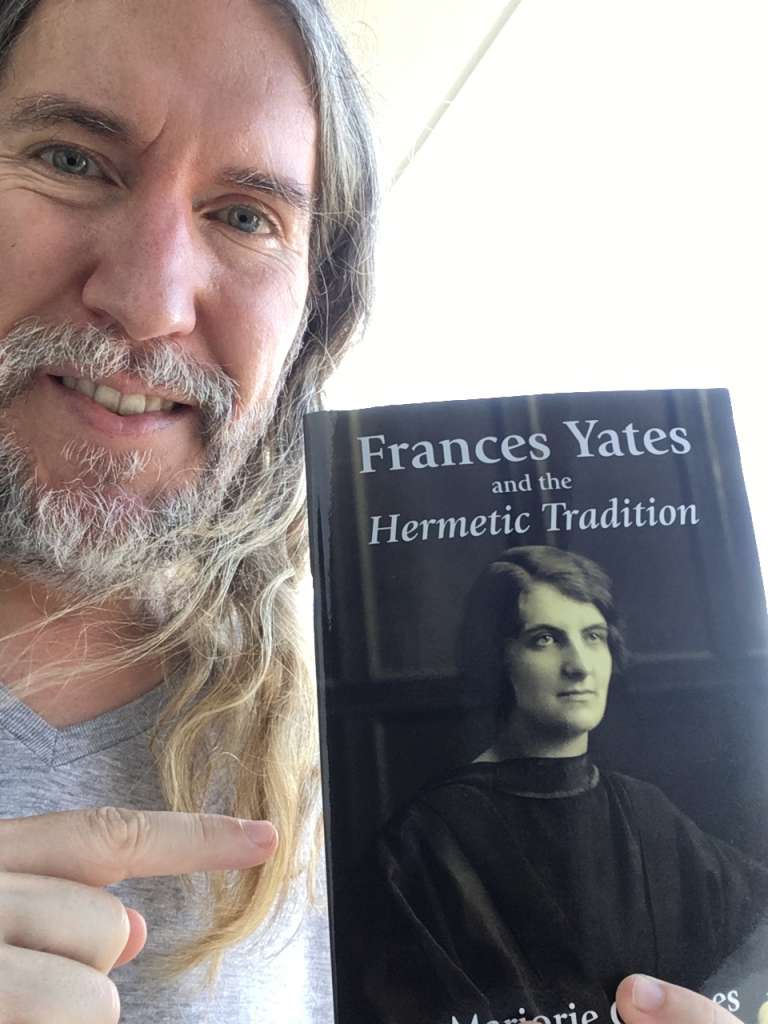 Anthony Metivier holding a copy of Frances Yates and the Hermetic Tradition