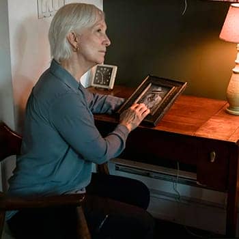 remembering memories feature image of a woman with a framed photo of a loved one