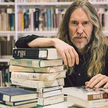 Lifelong learning feature image with Anthony Metivier in a library with books